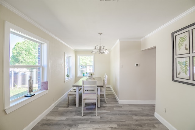 dining space featuring a notable chandelier, light hardwood / wood-style floors, and crown molding