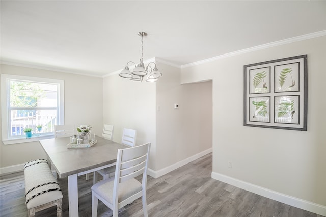 dining area with light hardwood / wood-style flooring, a notable chandelier, and ornamental molding