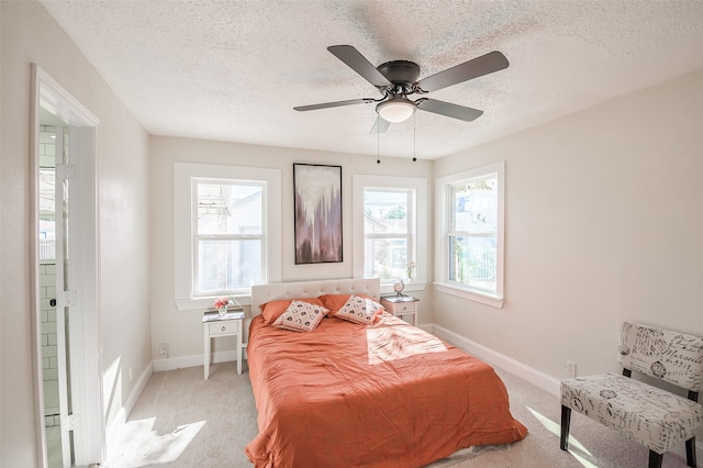 bedroom featuring ceiling fan, light colored carpet, a textured ceiling, and multiple windows