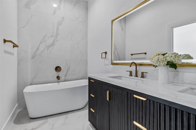 bathroom featuring marble look tile flooring, vanity, and a soaking tub