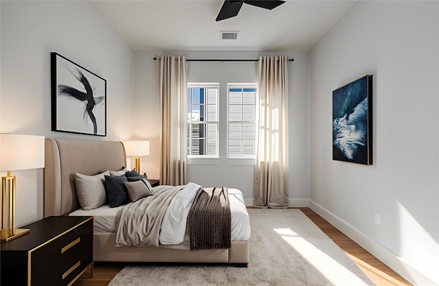 bedroom featuring wood finished floors, baseboards, and ceiling fan