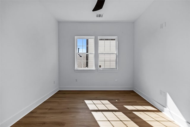 spare room featuring ceiling fan and dark wood-type flooring