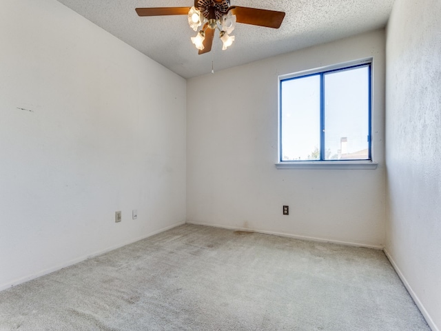 carpeted empty room featuring a textured ceiling and ceiling fan