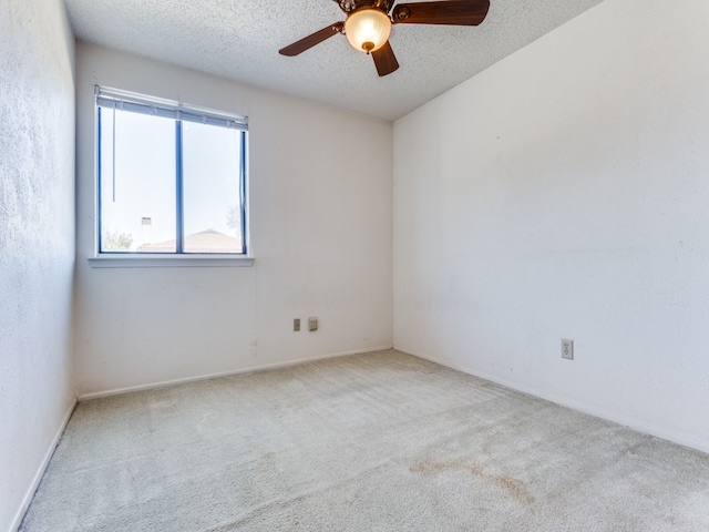 carpeted empty room featuring a textured ceiling and ceiling fan