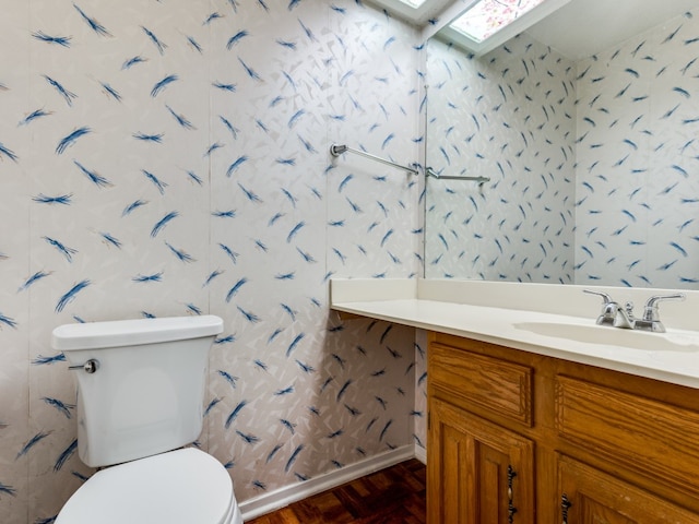 bathroom with wood-type flooring, vanity, and toilet