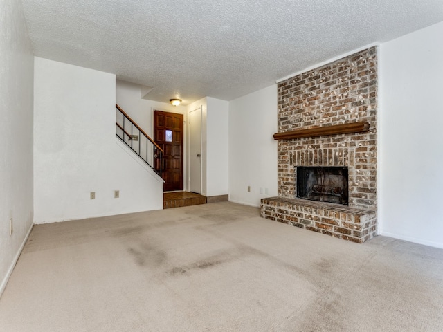 unfurnished living room with a fireplace, a textured ceiling, and carpet