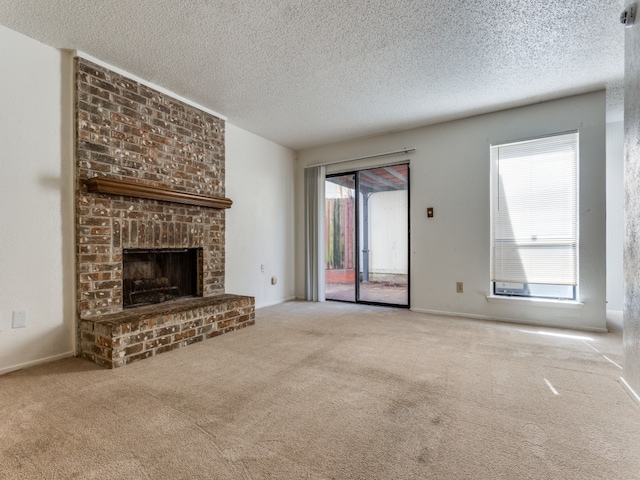 unfurnished living room with a brick fireplace, light colored carpet, and a textured ceiling