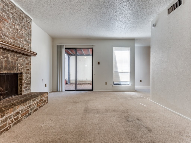 unfurnished living room with a textured ceiling, light carpet, and a brick fireplace