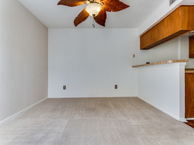 carpeted empty room with a textured ceiling and ceiling fan