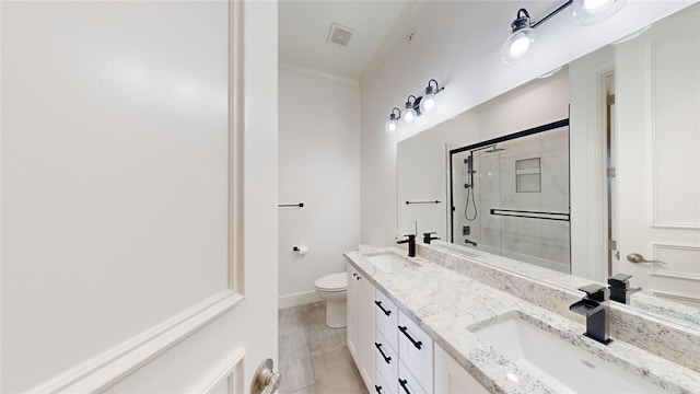 bathroom with toilet, vanity, crown molding, and walk in shower