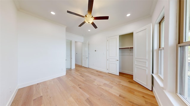 unfurnished bedroom with ceiling fan, ornamental molding, a closet, and light wood-type flooring