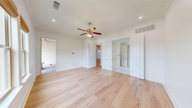 unfurnished bedroom featuring multiple windows, crown molding, ceiling fan, and light hardwood / wood-style floors