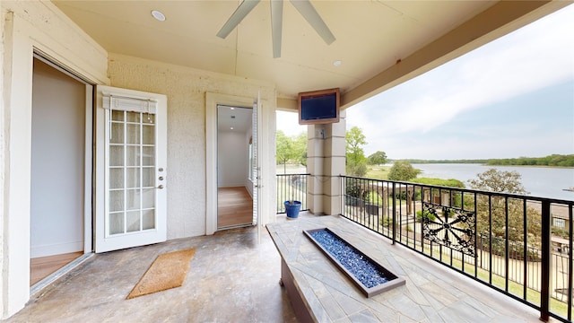 balcony featuring a water view and ceiling fan