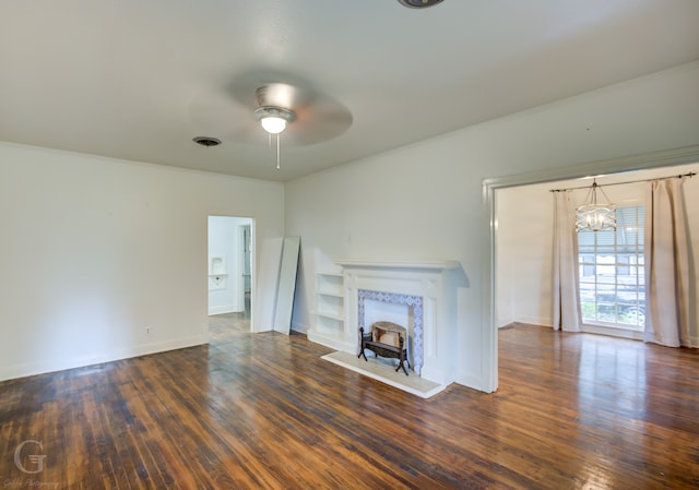 unfurnished living room featuring ornamental molding, ceiling fan with notable chandelier, and dark hardwood / wood-style floors