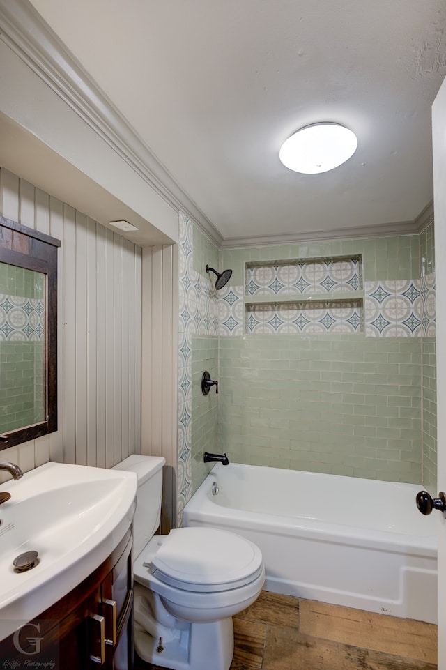 full bathroom with vanity, tiled shower / bath combo, wooden walls, hardwood / wood-style flooring, and toilet