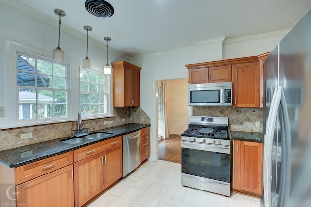 kitchen with sink, appliances with stainless steel finishes, ornamental molding, backsplash, and decorative light fixtures