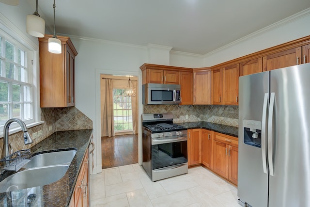 kitchen featuring hanging light fixtures, sink, tasteful backsplash, ornamental molding, and appliances with stainless steel finishes