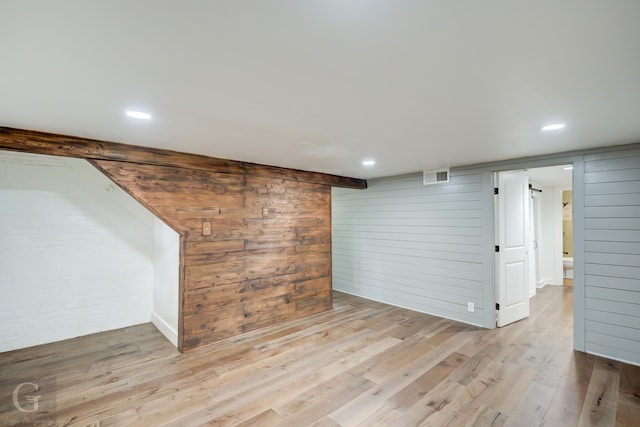 unfurnished living room featuring wood walls and light hardwood / wood-style floors