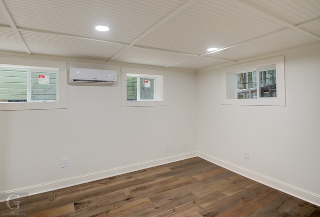 basement featuring dark wood-type flooring, a wall unit AC, and plenty of natural light