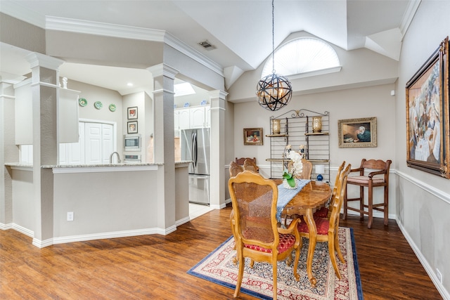 dining room with crown molding, dark hardwood / wood-style floors, lofted ceiling, and a notable chandelier