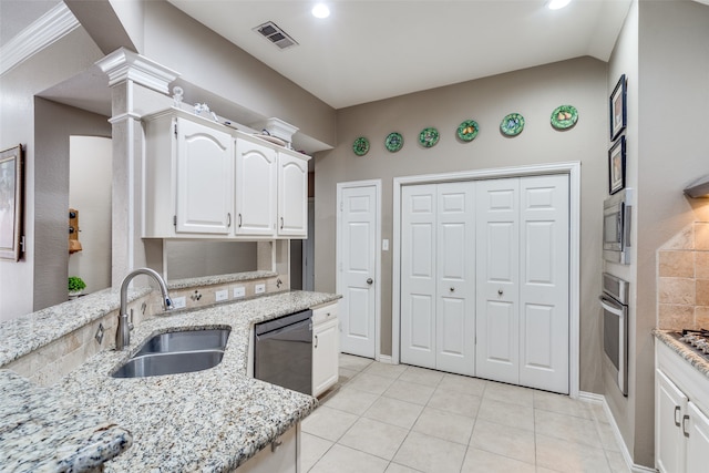 kitchen with sink, light tile patterned floors, light stone countertops, appliances with stainless steel finishes, and white cabinetry