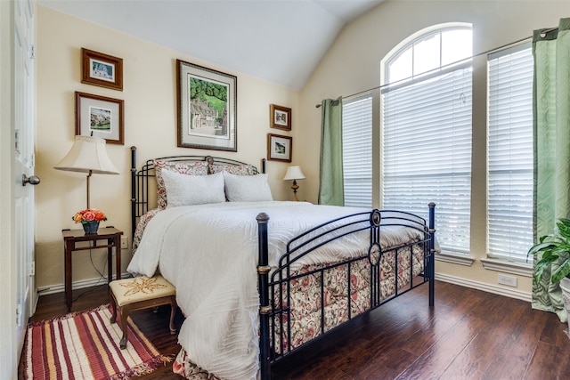 bedroom with dark wood-type flooring and lofted ceiling