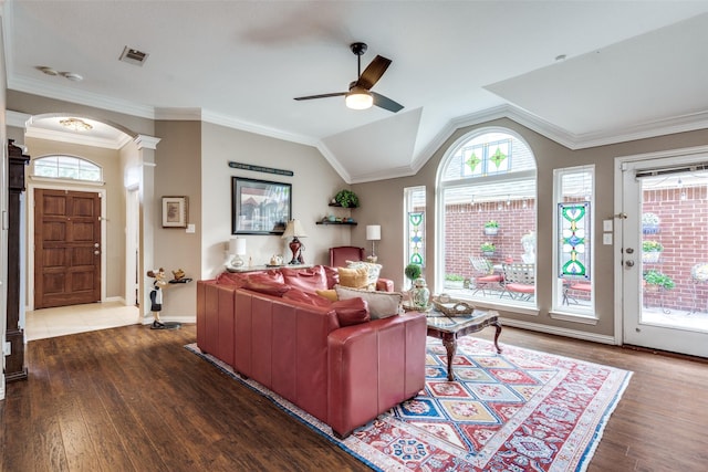 living room with dark wood-type flooring, ornate columns, lofted ceiling, and crown molding