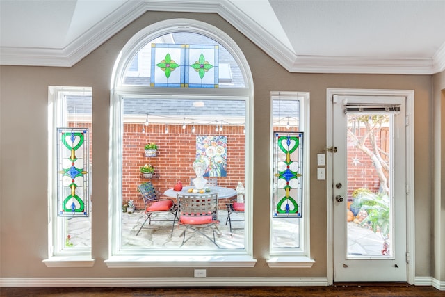 doorway to outside with a healthy amount of sunlight, lofted ceiling, and ornamental molding