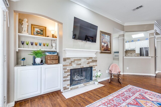 living room featuring a fireplace, crown molding, and dark hardwood / wood-style flooring