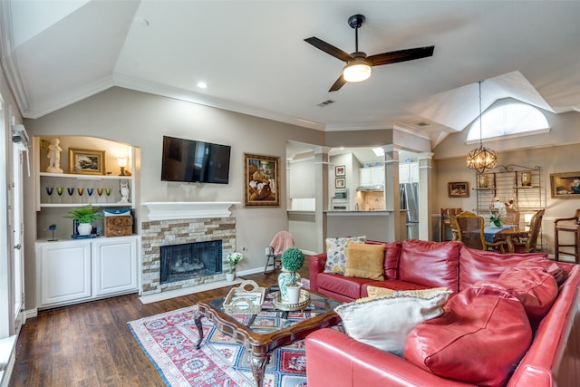 living room with dark wood-type flooring, a stone fireplace, crown molding, lofted ceiling, and ceiling fan with notable chandelier