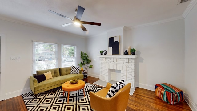 living room with ceiling fan, wood-type flooring, crown molding, and a brick fireplace