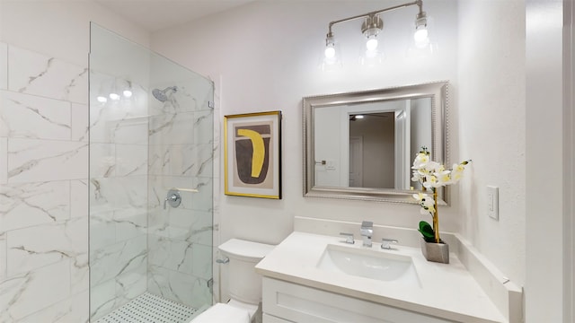 bathroom featuring a tile shower, vanity, and toilet