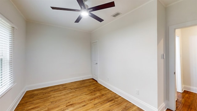 empty room with hardwood / wood-style floors, ceiling fan, and crown molding