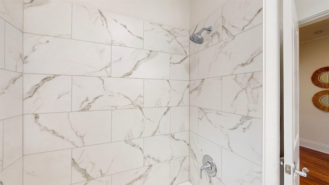 bathroom with wood-type flooring and tiled shower / bath