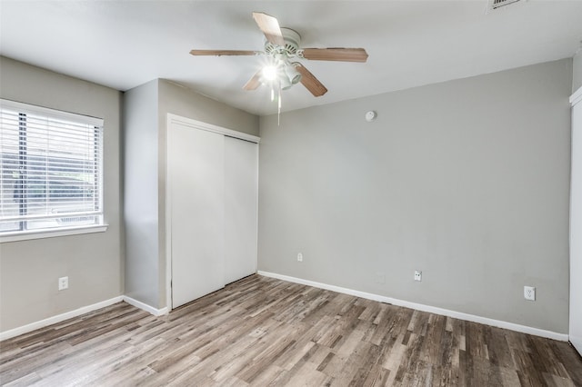 unfurnished bedroom with light hardwood / wood-style floors, a closet, and ceiling fan