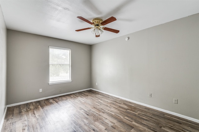 spare room with dark hardwood / wood-style floors and ceiling fan