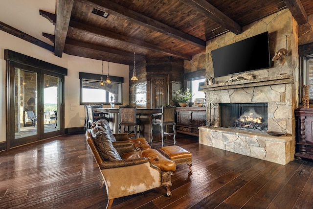 living room with hardwood / wood-style floors, a stone fireplace, wooden ceiling, and beamed ceiling