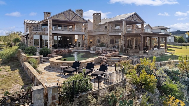 back of house featuring a balcony and a patio area