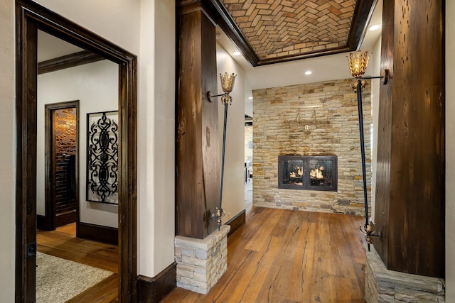 interior space with brick ceiling, wood-type flooring, and ornamental molding