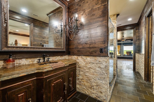 bathroom featuring vanity, wooden walls, and ceiling fan