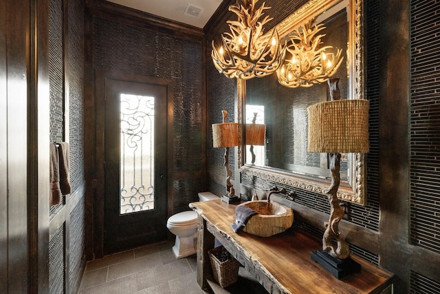 bathroom featuring sink, toilet, tile patterned flooring, and a notable chandelier