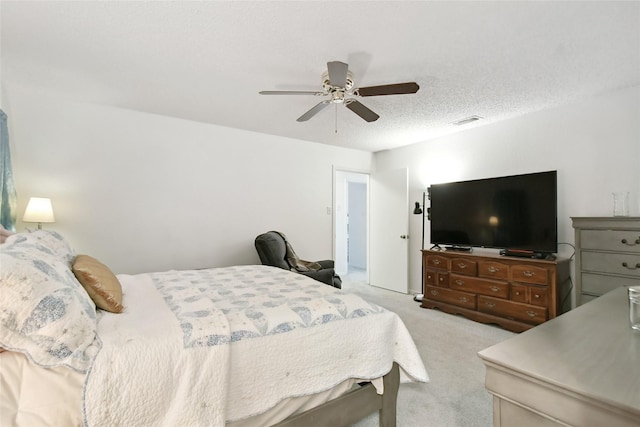 carpeted bedroom with ceiling fan and a textured ceiling