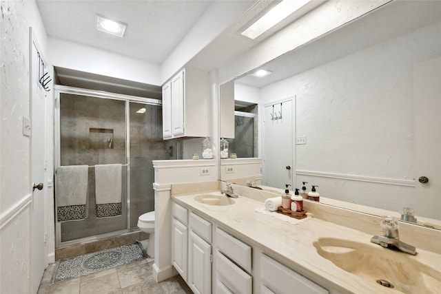 bathroom featuring tile patterned flooring, vanity, an enclosed shower, and toilet