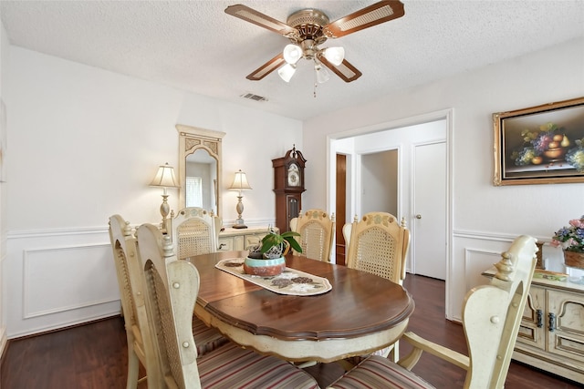 dining space featuring a textured ceiling, dark hardwood / wood-style floors, and ceiling fan