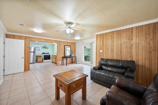 living room featuring wooden walls, crown molding, and ceiling fan