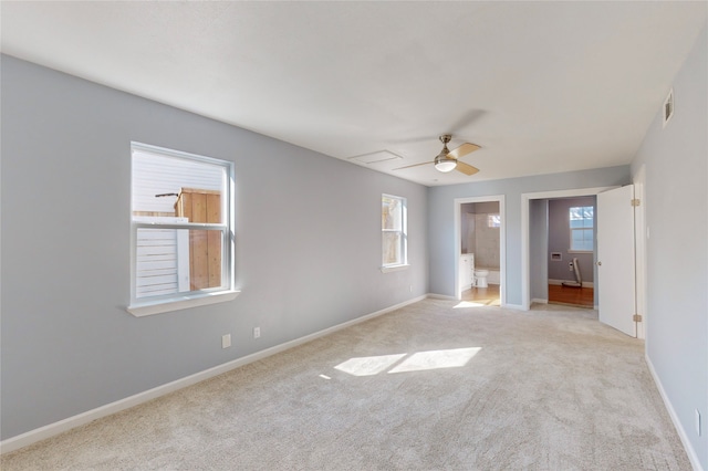 empty room with ceiling fan, a healthy amount of sunlight, and light carpet