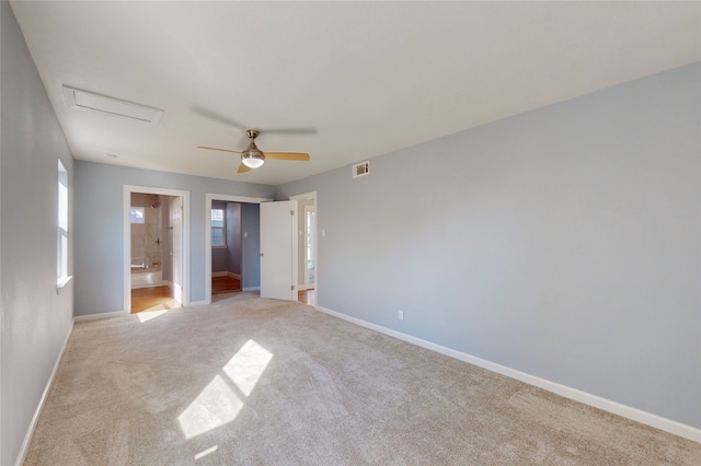 unfurnished bedroom featuring ensuite bathroom, light carpet, and ceiling fan