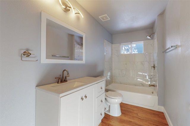 full bathroom with vanity, hardwood / wood-style flooring, toilet, and tiled shower / bath