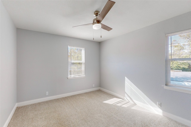 spare room featuring light colored carpet and ceiling fan