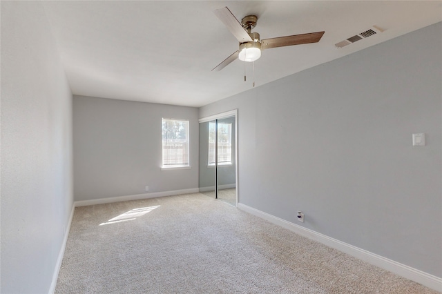 empty room featuring light carpet and ceiling fan